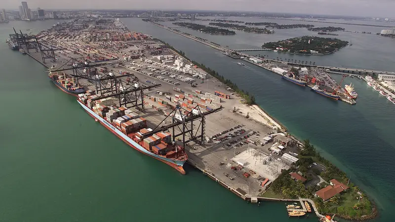 Aerial view of a busy container port with cranes and a cargo ship